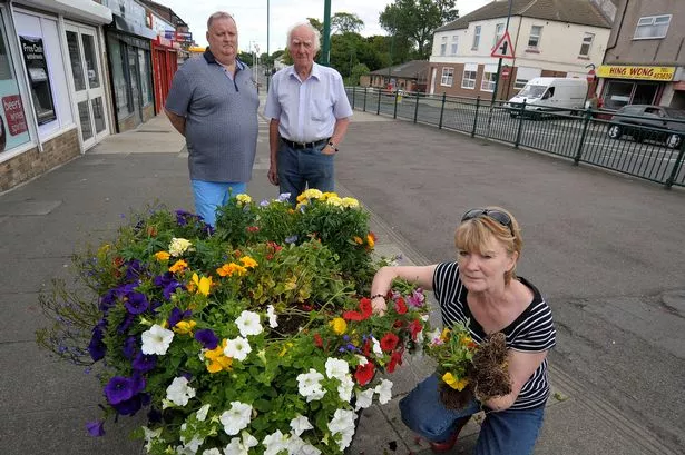 Eston Residents Association are angry over vandalism yet again to their flower tubs shortly before Britain in Bloom judges are due. Chair of the Residents Association Ann Higgins front with rear Dave Fisher & Ray Clements.
