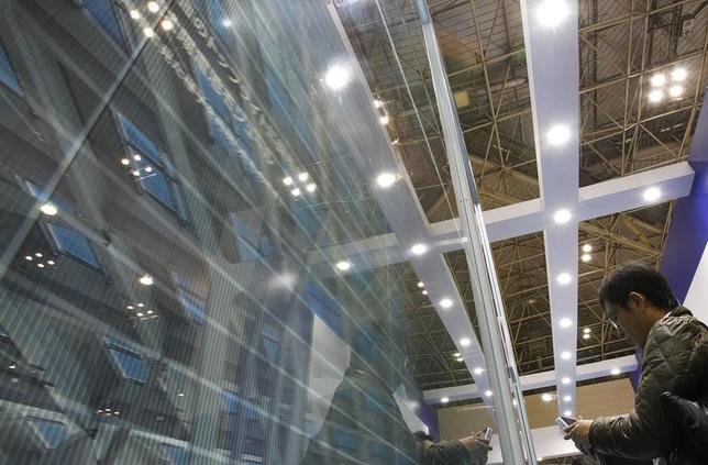 A visitor takes a photograph of Sharp Corp's see-through photovoltaic module, displayed at the fourth International Photovoltaic Power Generation (PV) Expo in Tokyo March 2, 2011. REUTERS/Yuriko Nakao