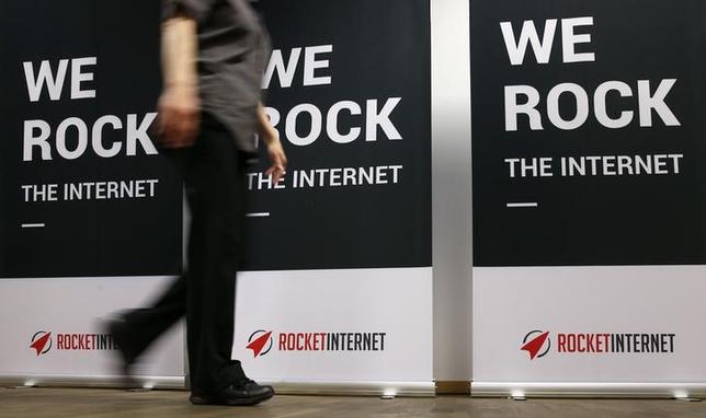 A woman walks past a banner at the shareholder meeting of Rocket Internet, a German venture capital group in Berlin, Germany, June 23, 2015. REUTERS/Fabrizio Bensch