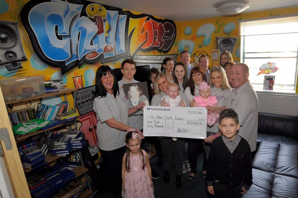 Parents Richard and Tracy Clarke family and friend fund raisers hand over the cash