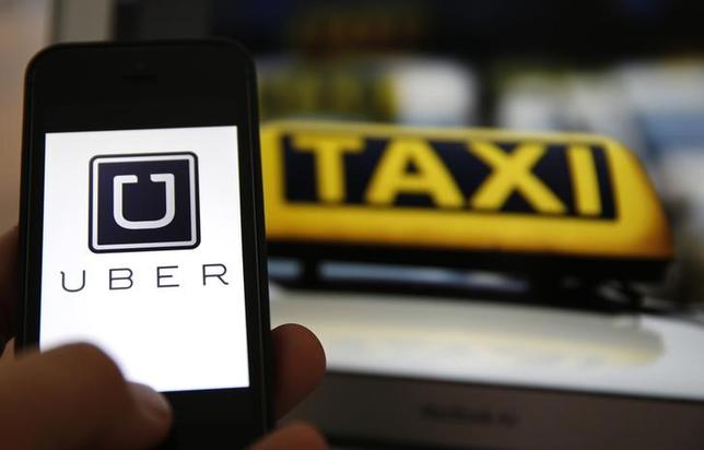 An illustration picture shows the logo of car-sharing service app Uber on a smartphone next to the picture of an official German taxi sign in Frankfurt, September 15, 2014. REUTERS/Kai Pfaffenbach