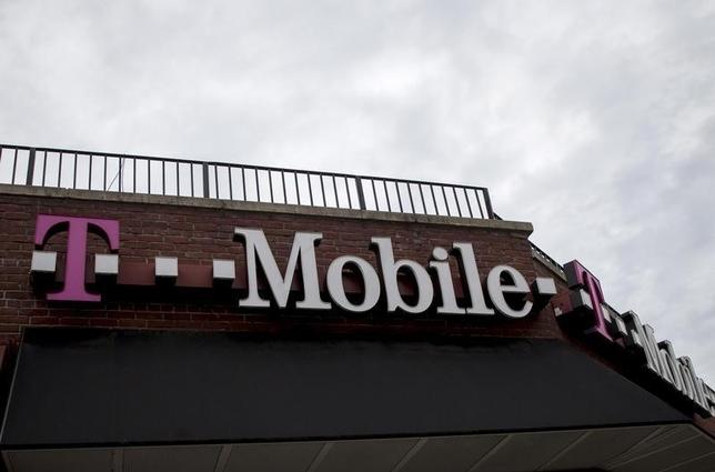 People pass by a T-Mobile store in the Brooklyn borough of New York June 4, 2015. REUTERS/Brendan McDermid