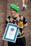 A runner wearing fancy dress holds a Guinness World Record certificate for the fastest runner dressed as a golfer at the finish line of the 2010 London Marathon in London on April 25, 2010. AFP PHOTO/BEN STANSALL