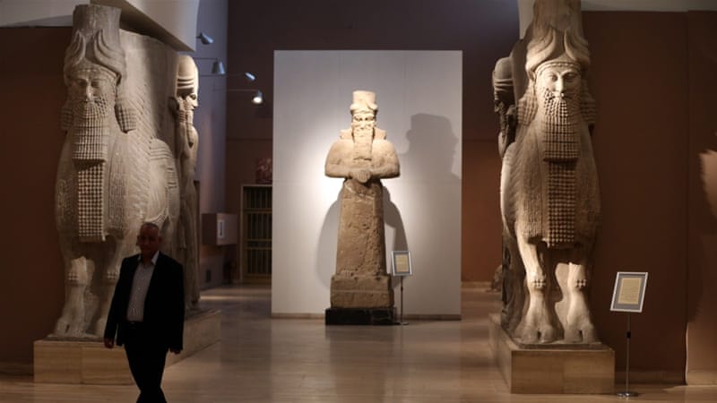 A man at Iraq's National Museum in Baghdad walks past two ancient Assyrian human-headed winged bull statues [AP]