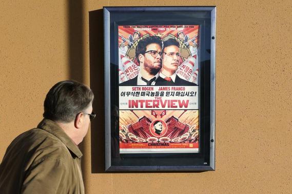 A man walks by the poster for the film 'The Interview' outside the Alamo Drafthouse theater in Littleton, Colorado December 23, 2014. REUTERS/Rick Wilking