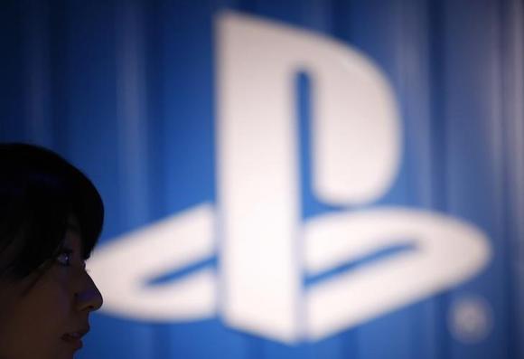 The logo of Sony Corp's PlayStation is seen next to a woman at its booth during the Tokyo Game Show 2014 in Makuhari, east of Tokyo September 18, 2014. REUTERS/Yuya Shino