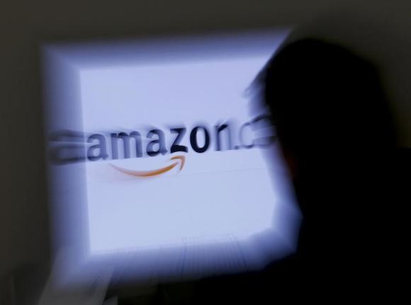 A zoomed illustration image of a man looking at a computer monitor showing the logo of Amazon is seen in Vienna November 26, 2012. To match Special Report TAX-AMAZON REUTERS/Leonhard Foeger
