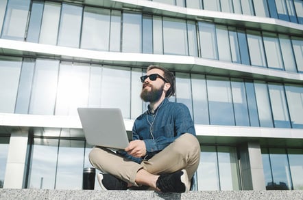 Hipster with laptop photo via Shutterstock