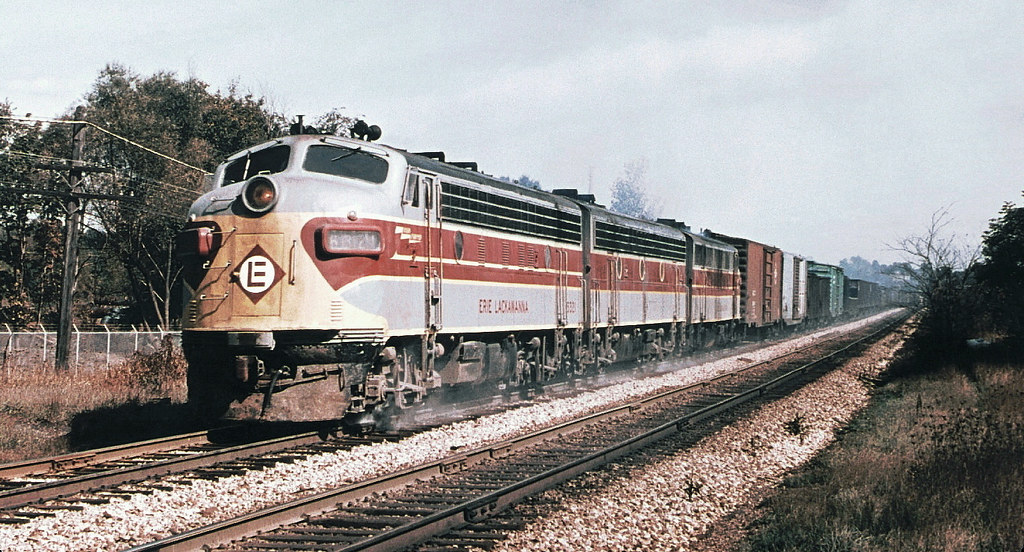 Erie Lackawanna EMD F7A diesel electric locomotive # 6321, is seen leading two other F units while hauling a mixed merchandise freight train along the mainline at Kent, Ohio, October 1969