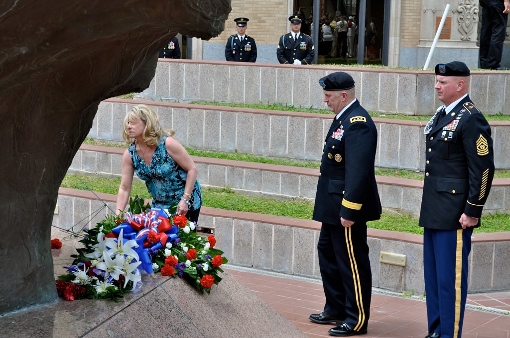 Mrs. Sarah Lynch lays a flower at the base of the Vietnam War's Battle of Hill 881 South monument during San Antonio Fiesta's All-Veterans Memorial Service