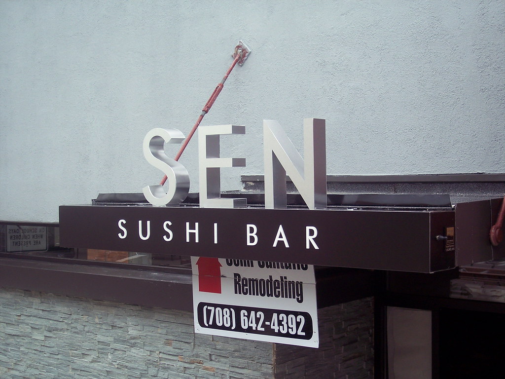 Fabricated stainless steel letters, bottom mounted to raceway, illuminated from bottom. SUSHI BAR letters are push through acrylic and illluminated.