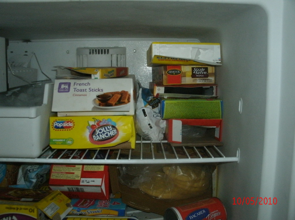 Open boxes of food in freezer in apartment