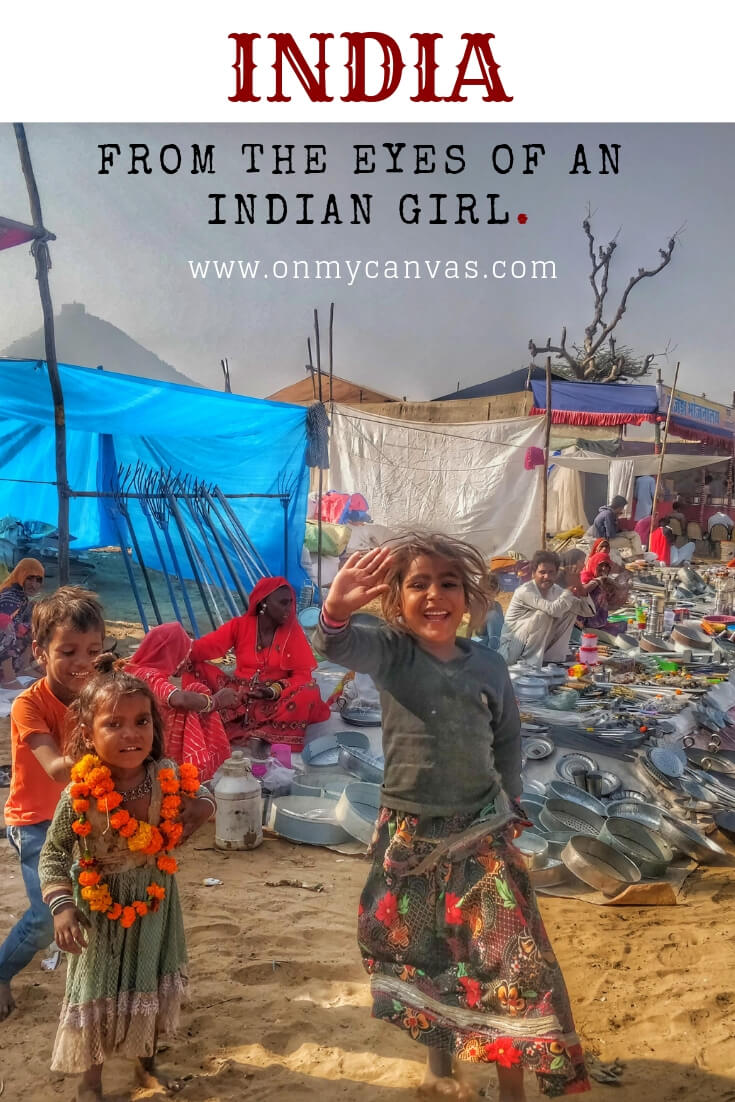 A little girl smiling and saying hi in pushkar mela rajasthan india photo is being used for the pinterest image for a indian woman story about India